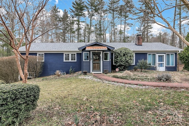 single story home featuring a chimney, a front lawn, and a shingled roof