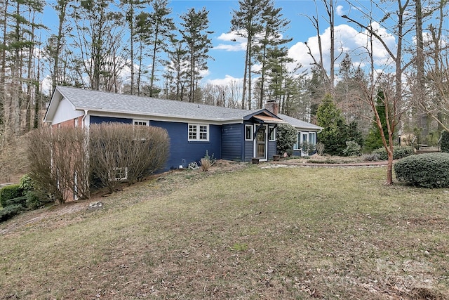 rear view of property featuring a yard and a chimney