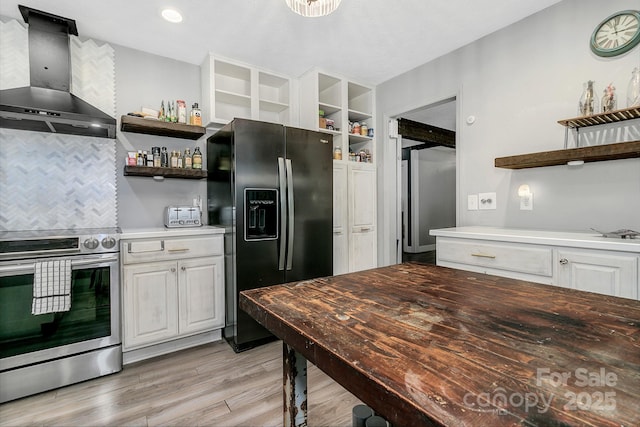 kitchen featuring open shelves, black fridge with ice dispenser, light wood-style floors, stainless steel electric range, and wall chimney exhaust hood