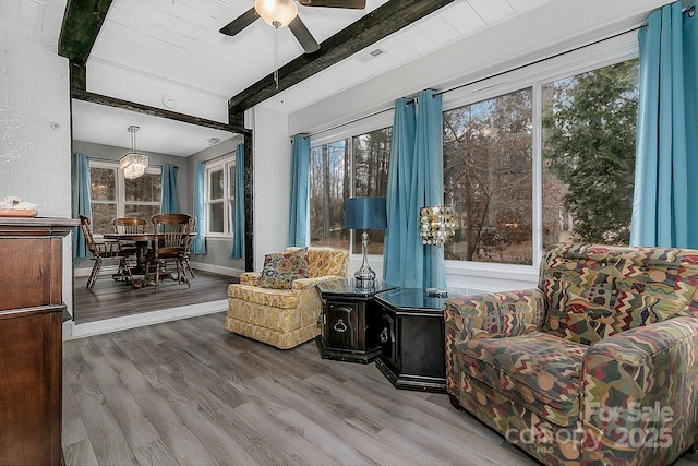 sunroom featuring visible vents, beam ceiling, and ceiling fan