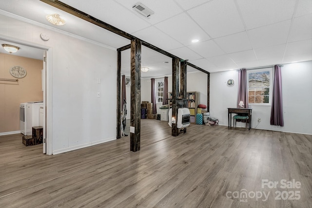 interior space featuring a drop ceiling, visible vents, washing machine and dryer, and wood finished floors