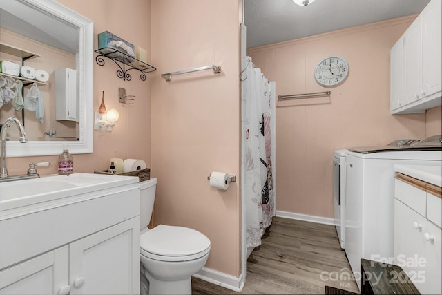 full bath with curtained shower, toilet, wood finished floors, vanity, and separate washer and dryer