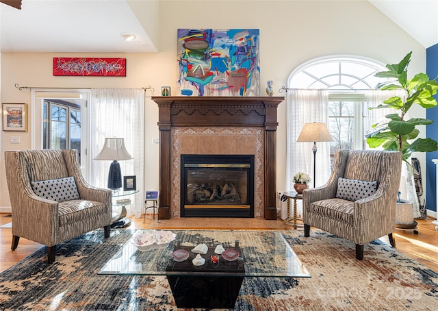 living area with a healthy amount of sunlight, vaulted ceiling, and light wood-type flooring