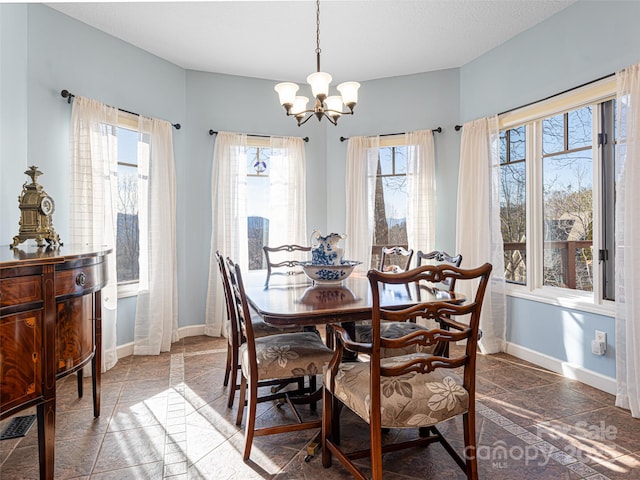 dining area featuring a notable chandelier and a textured ceiling