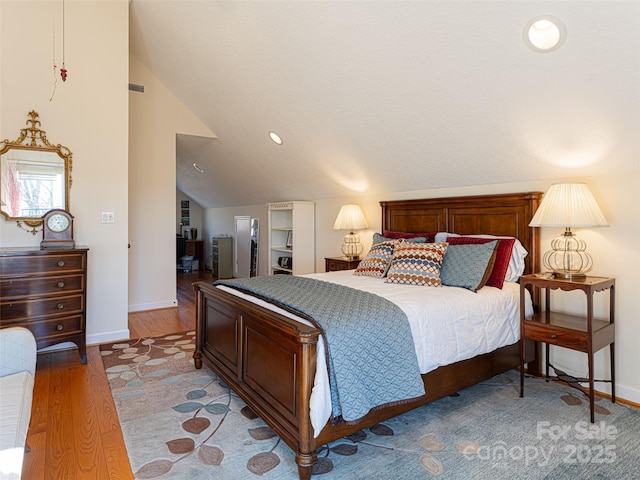 bedroom with vaulted ceiling and light hardwood / wood-style floors