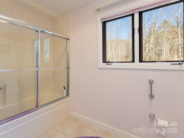 bathroom with shower / bath combination with glass door and tile patterned flooring