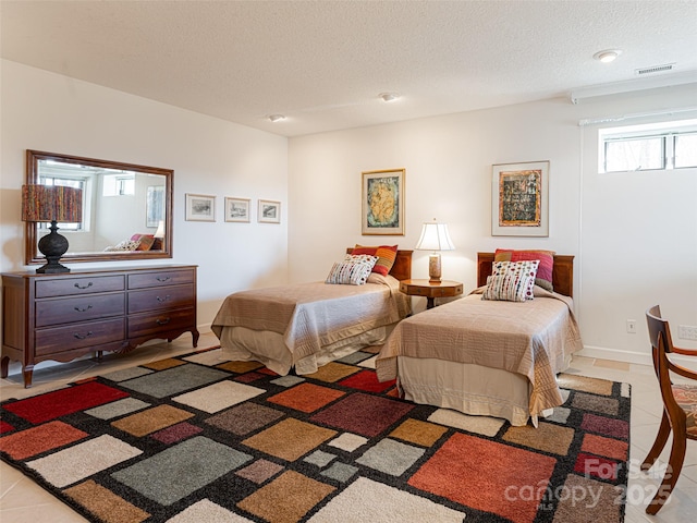 bedroom featuring light tile patterned floors and a textured ceiling