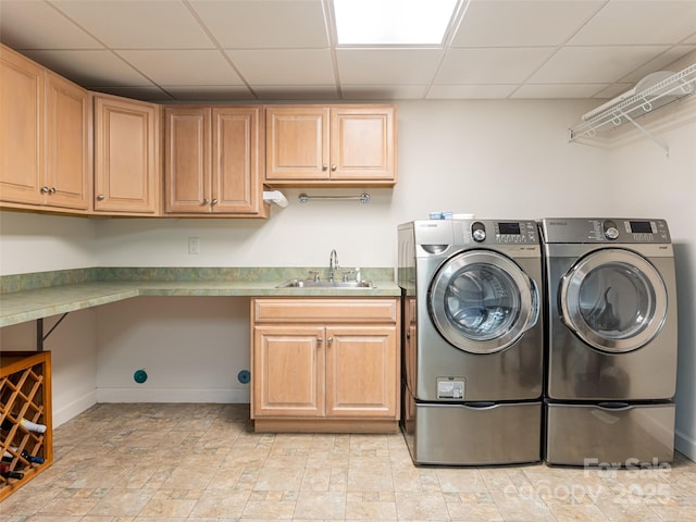 laundry area featuring sink, cabinets, and washing machine and clothes dryer