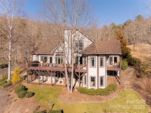 rear view of house with a lawn and a deck