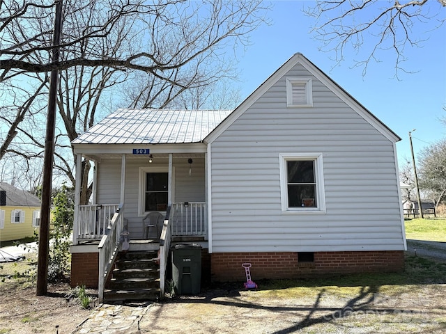 view of front of property with a porch, metal roof, and crawl space