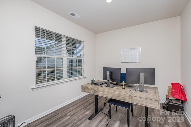 office space featuring wood finished floors, visible vents, and baseboards