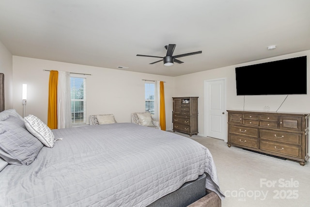 bedroom featuring light colored carpet, ceiling fan, and visible vents