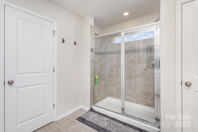 full bath featuring a shower stall, baseboards, and tile patterned flooring