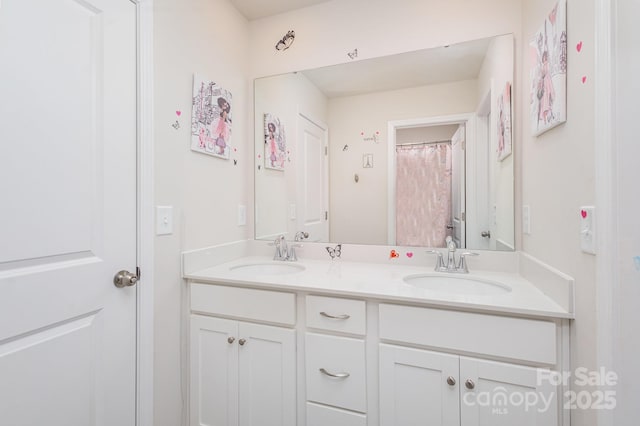 bathroom featuring a sink and double vanity