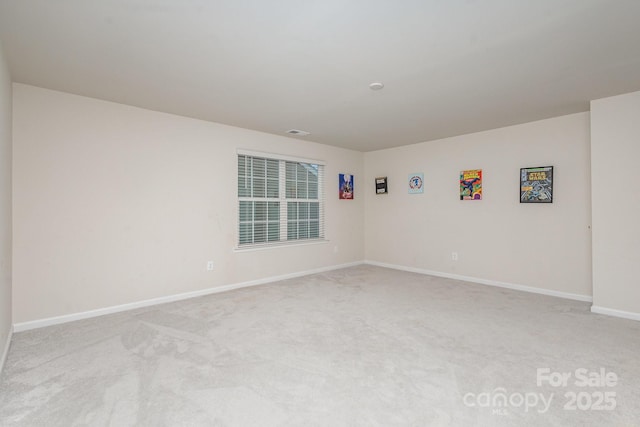 empty room featuring light carpet, visible vents, and baseboards