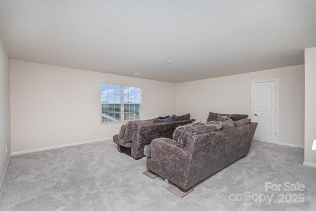 living area with baseboards and light colored carpet