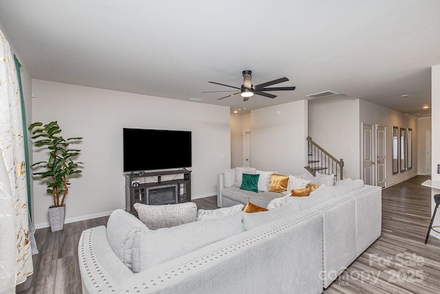 living area with baseboards, visible vents, ceiling fan, and wood finished floors