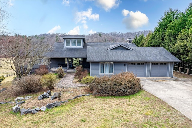 view of front of house with an attached garage, driveway, a front lawn, and a shingled roof