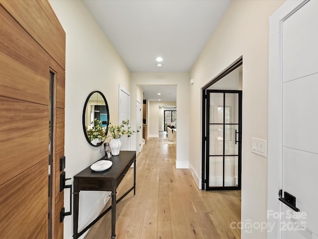 corridor featuring light wood-style flooring, recessed lighting, and baseboards