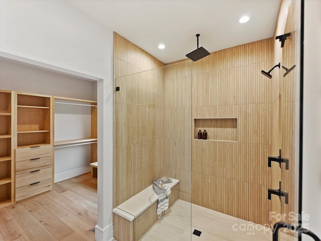 full bath with recessed lighting, walk in shower, wood finished floors, and a spacious closet