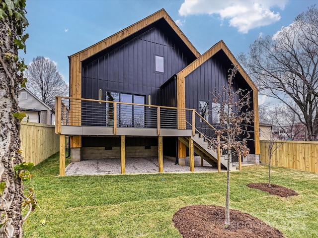 back of property featuring stairway, a fenced backyard, a lawn, and a wooden deck