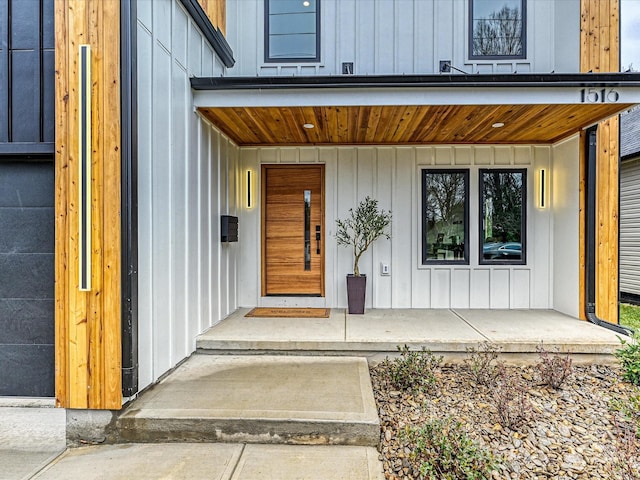 property entrance with board and batten siding and covered porch