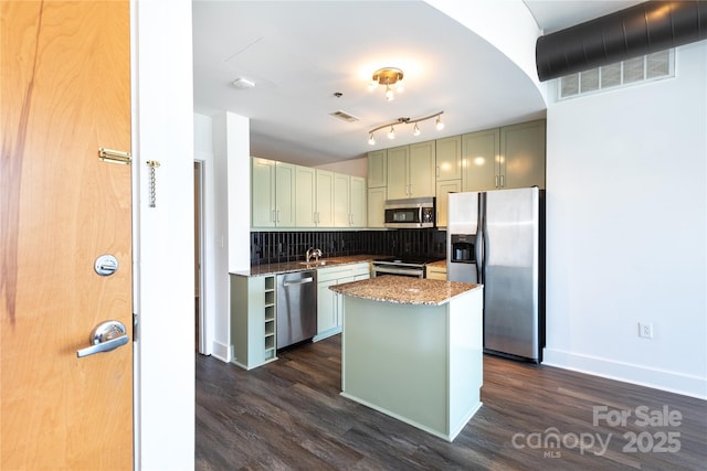 kitchen featuring visible vents, a sink, stainless steel appliances, arched walkways, and decorative backsplash