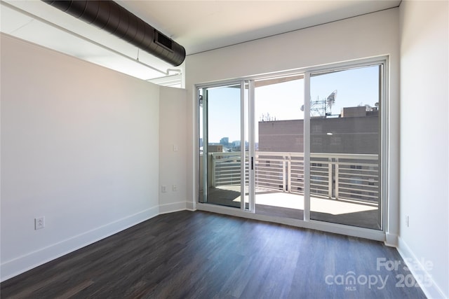 unfurnished room featuring baseboards and wood finished floors