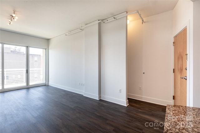 empty room with dark wood finished floors and baseboards