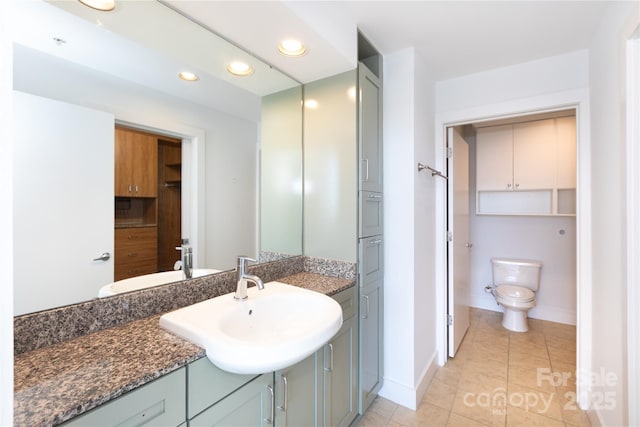 bathroom featuring vanity, baseboards, recessed lighting, tile patterned flooring, and toilet