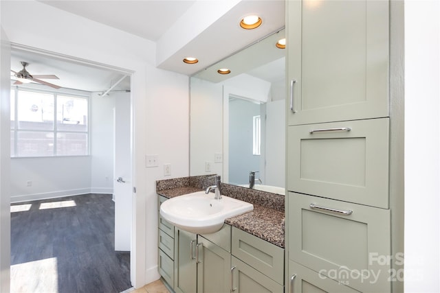 bathroom with baseboards, ceiling fan, recessed lighting, wood finished floors, and vanity