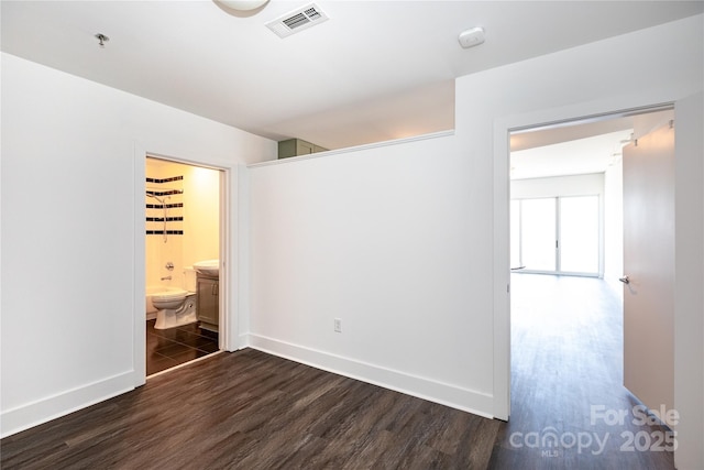 interior space featuring visible vents, baseboards, and dark wood-style floors