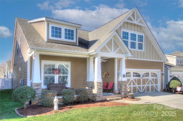 craftsman-style home featuring a garage, covered porch, and a front yard