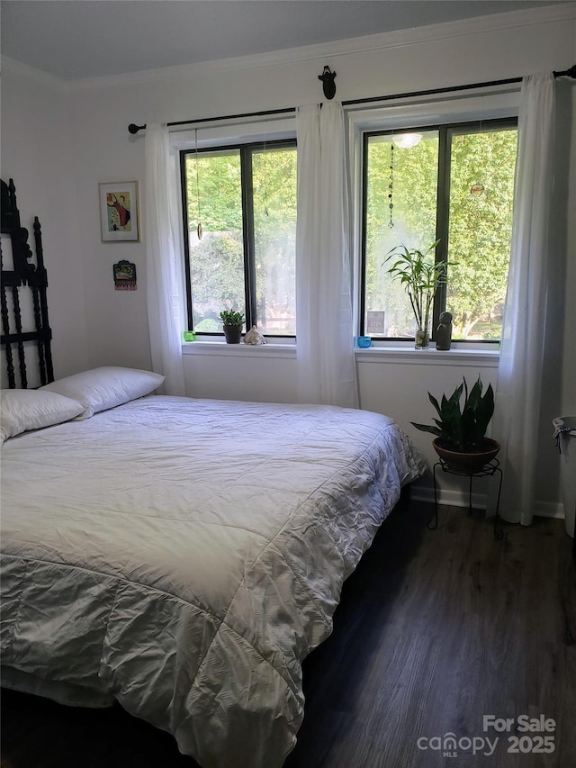 bedroom with ornamental molding, dark wood-style flooring, and multiple windows