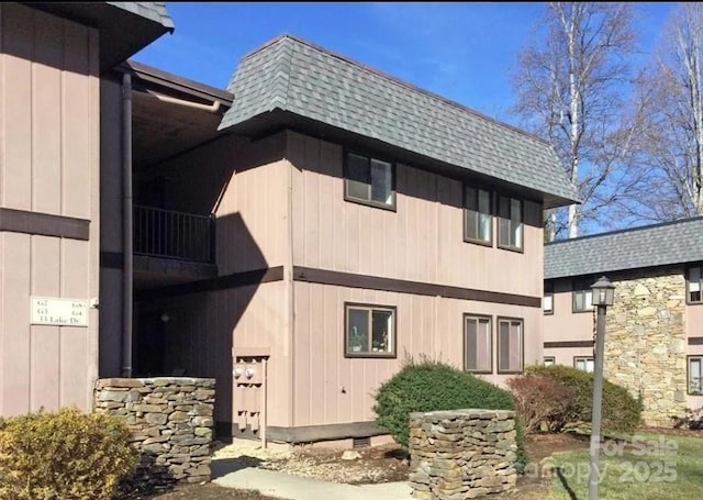 view of property exterior featuring crawl space, roof with shingles, and mansard roof