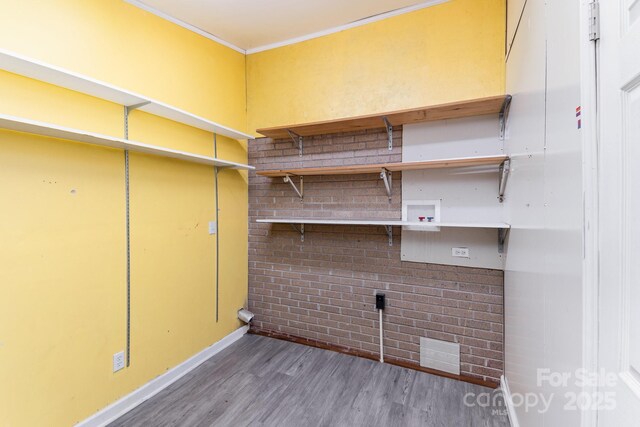 clothes washing area featuring hookup for a washing machine, crown molding, laundry area, wood finished floors, and visible vents