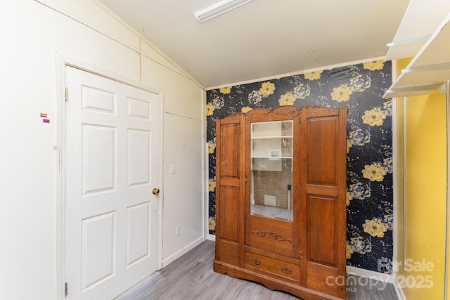 bedroom with wallpapered walls and light wood-style flooring