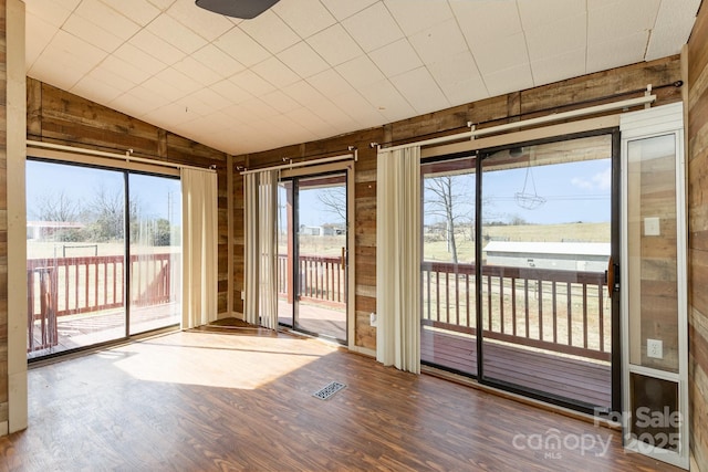 unfurnished sunroom with visible vents and lofted ceiling