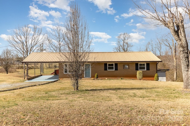 view of front of property featuring a front yard, metal roof, and brick siding