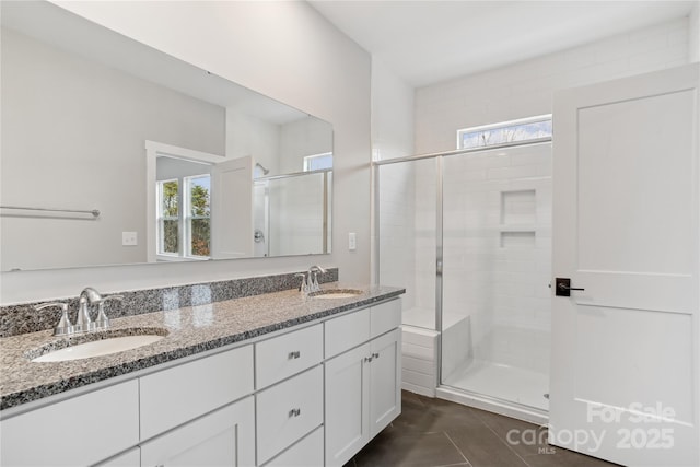 bathroom with vanity, tile patterned floors, a healthy amount of sunlight, and walk in shower