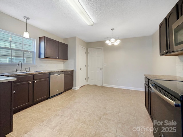 kitchen with appliances with stainless steel finishes, pendant lighting, sink, decorative backsplash, and dark brown cabinetry