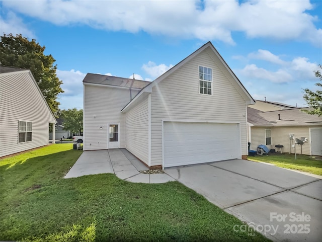 back of house with a yard and a garage