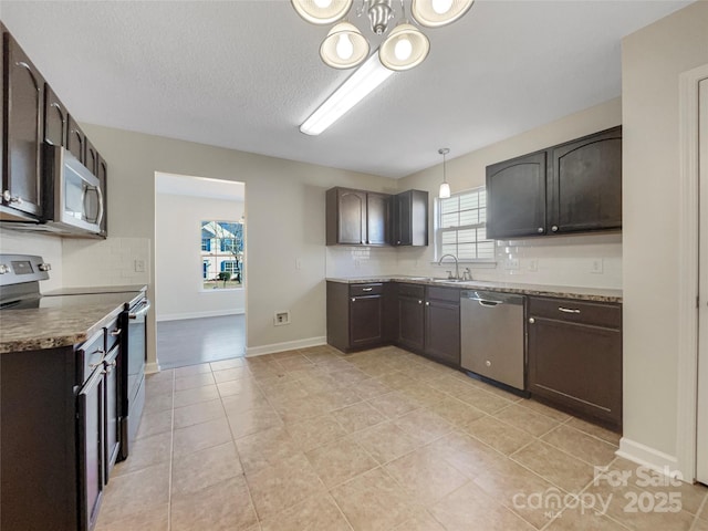 kitchen featuring stainless steel appliances, hanging light fixtures, dark brown cabinets, and decorative backsplash