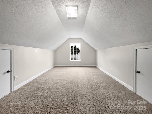 bonus room with lofted ceiling, carpet floors, and a textured ceiling