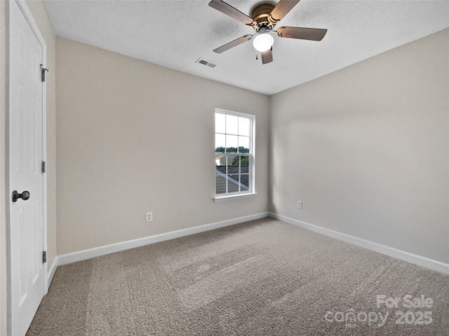 carpeted empty room featuring ceiling fan and a textured ceiling