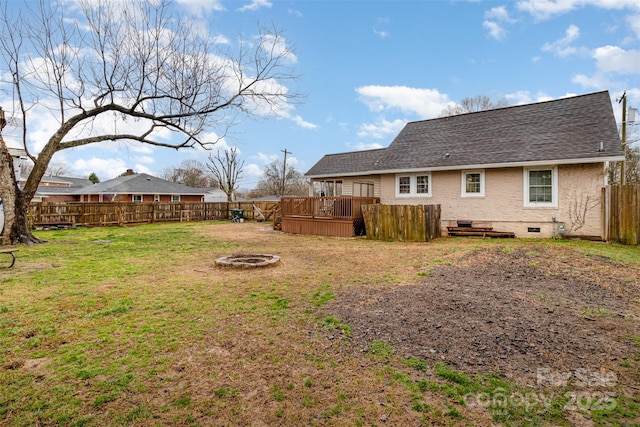 view of yard with a wooden deck and an outdoor fire pit