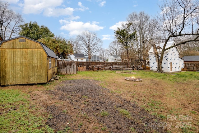 view of yard with a storage shed and a fire pit