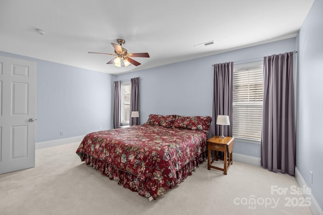 bedroom featuring visible vents, baseboards, a ceiling fan, and light colored carpet