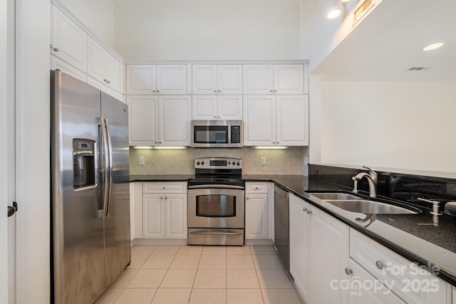 kitchen featuring appliances with stainless steel finishes, backsplash, a sink, and white cabinetry