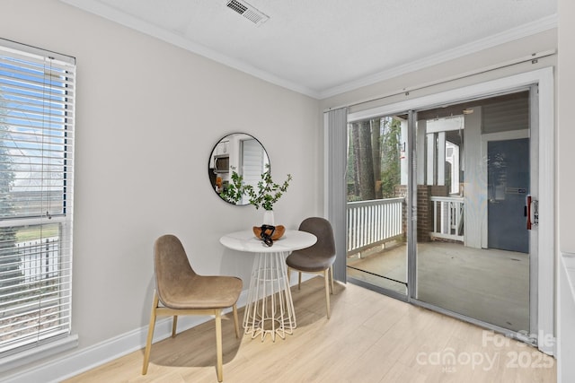 sitting room featuring ornamental molding and light wood-type flooring